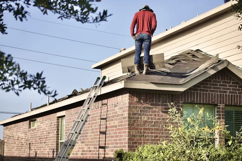 Professional roofer working on a residential roof in The Country Club